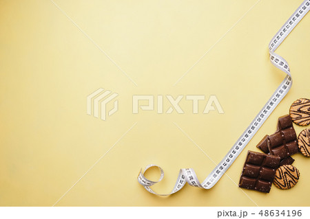 chocolate bar and measure tape. diet and fitness 48634196