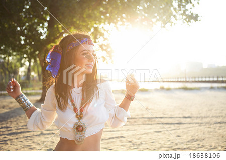 Happy slim tan woman in jeans dancing on the beach 48638106