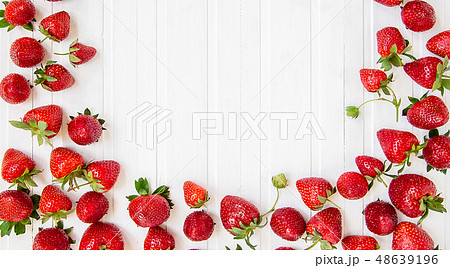 Ripe red strawberries scattered on a white wooden  48639196