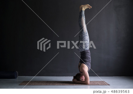 woman practicing yoga, doing headstand exercise  48639563