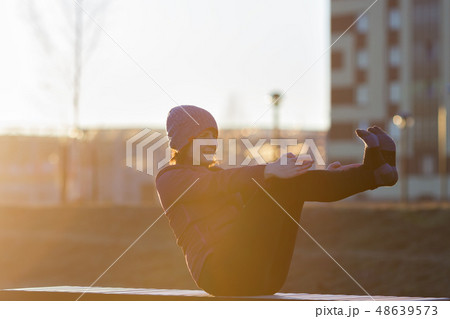 A girl in sports clothes doing a boat pose 48639573