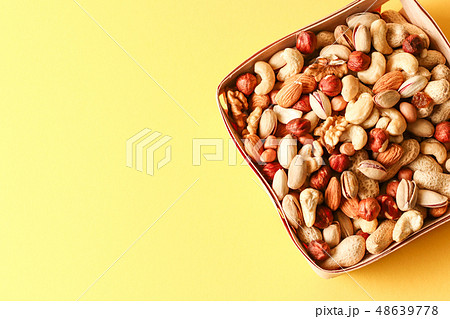 Dried fruits and nuts mix in a wooden bowl.  48639778