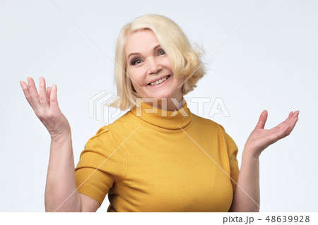 Beautiful older woman in yellow sweater smiling Beautiful older woman in yellow sweater smiling 48639928