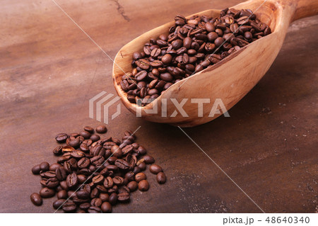 Old wooden scoop with coffee beans, coffee grinder and Turkish coffee in Cezve on dark stone table. 48640340