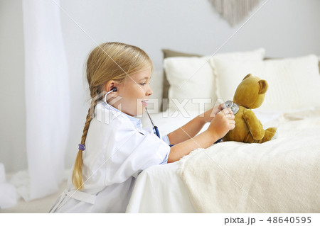 Little blond girl with stethoscope playing with Little blond girl with stethoscope playing with 48640595