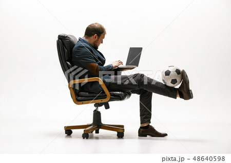 Businessman with football ball in office Businessman with football ball in office 48640598