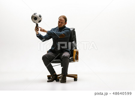 Businessman with football ball in office Businessman with football ball in office 48640599