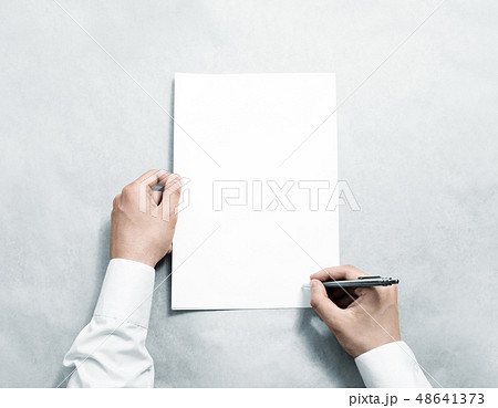 Hand holding blank agreement mockup and signing it. Hand holding blank agreement mockup and signing it. 48641373