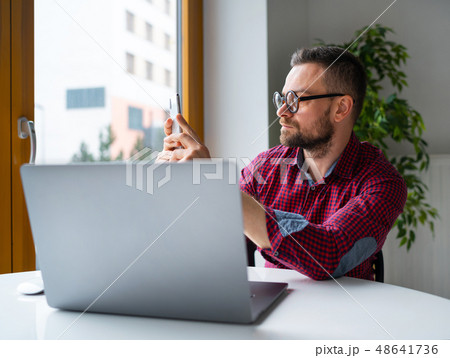 Man in glasses sitting at home office and working Man in glasses sitting at home office and working 48641736
