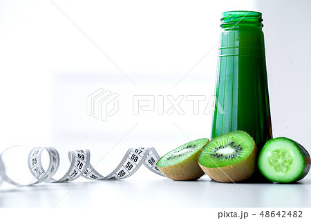 Diet. Composition with a glass of kiwi juice fresh, kiwis and a tape measuring Diet. Composition with a glass of kiwi juice fresh, kiwis and a tape measuring 48642482