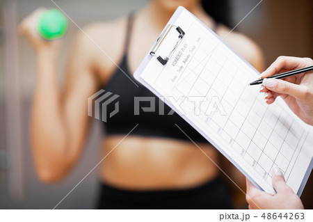 Fitness plan. Sports trainer amounts to workout plan close-up 48644263