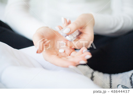 Medicine herb. Herbal pills in hand, palm, fingers with healthy medical plant. Vitamin supplement 48644437