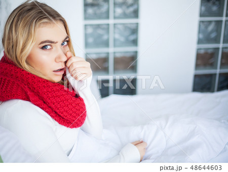 Sick woman with flu. Woman Suffering From Cold Lying In Bed With Tissue 48644603