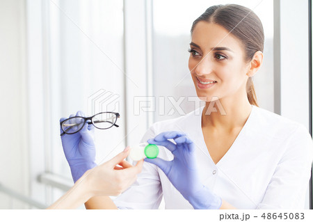Health. Young Girl Holds Contact Lens In Hands. Portrait of a Beautiful Woman with Green Eyes and 48645083