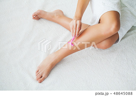 Caucasian woman shaving legs with razor at home 48645088
