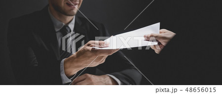 Businessman giving bribe money in the envelope to Businessman giving bribe money in the envelope to 48656015