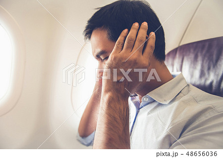 Male passenger having ear pop on the airplane Male passenger having ear pop on the airplane 48656036