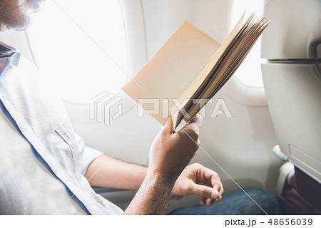 Passenger killing time by reading book while Passenger killing time by reading book while 48656039