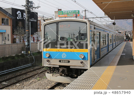 Blue train on railroad tracks with Mount Fuji 48657940