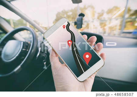 Hand with smartphone in a car Hand with smartphone in a car 48658507