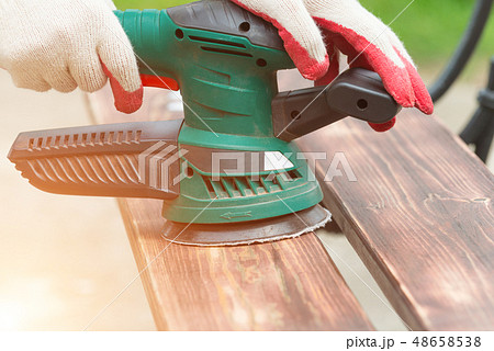 Sanding a wood with orbital sander Sanding a wood with orbital sander 48658538