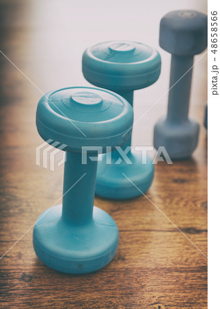 Blue dumb-bells on a flor 48658566