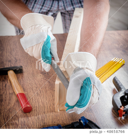 Man sanding a wood in a workshop 48658766