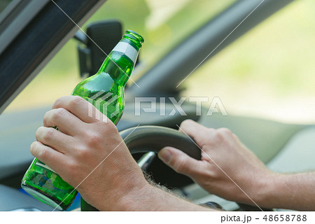 Man drinking beer in a car 48658788
