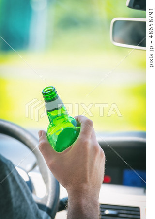 Man drinking beer while driving a car Man drinking beer while driving a car 48658791