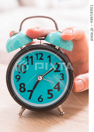 Hand on the alarm clock 48658901