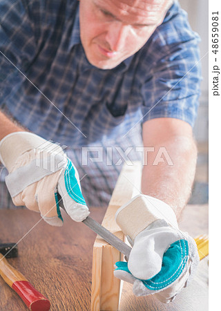 Man sanding a wood in a workshop 48659081