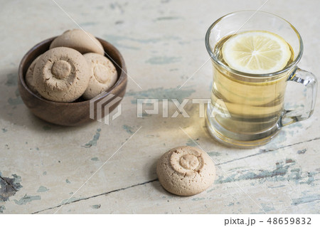 Glass of herbal tea and cookies on a wooden table Glass of herbal tea and cookies on a wooden table 48659832