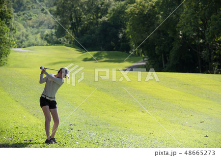 Asian woman playing golf on natural golf course Asian woman playing golf on natural golf course 48665273