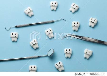 Healthy white teeth are smiling on blue background and dentist tools mirror, hook. Healthy white teeth are smiling on blue background and dentist tools mirror, hook. 48666962