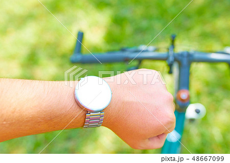 Man with smart watches on a bike Man with smart watches on a bike 48667099
