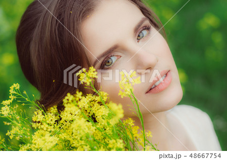 Young beautiful girl in field with yellow flowers 48667754