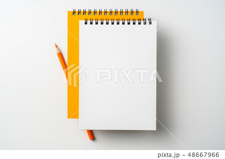 two spiral orange notebook and pen on white 48667966