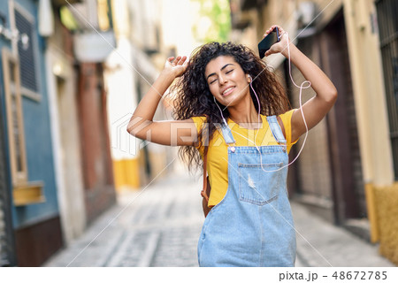 Attractive African girl listening to music with 48672785