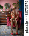 The girl in the red dress and red shoes on the couch 48673579