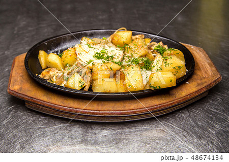 fried potatoes with meat in a frying pan 48674134