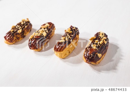 Food, desserts and bakery concept - Traditional French dessert eclairs with chocolate and nuts 48674433