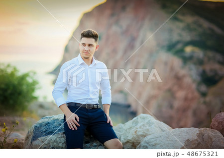 Happy young family pregnant pretty girl with husband on the cliff in mountains over sunset lights 48675321