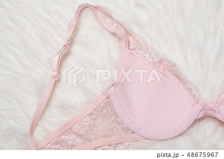 Pink lace bra on white fur, inner side. Flat lay. Pink lace bra on white fur, inner side. Flat lay. 48675967