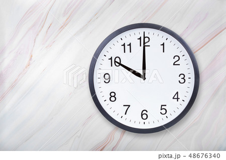 Wall clock show ten o'clock on marble texture. Office clock show 10pm or 10am Wall clock show ten o'clock on marble texture. Office clock show 10pm or 10am 48676340