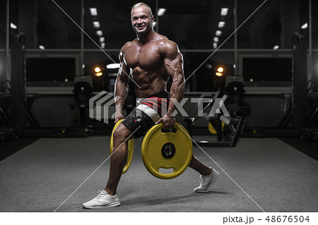 Handsome strong bodybuilder athletic men pumping 48676504