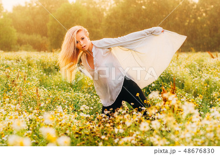 Portrait of young girl dancing in chamomile field 48676830