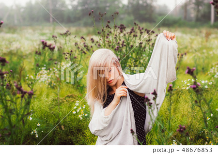 Portrait of young girl dancing in chamomile field 48676853