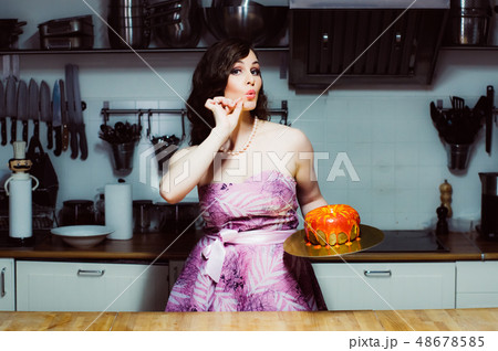 Hostess holds cake like big donut with fondant 48678585