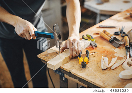 The carpenter works with a tree 48681089