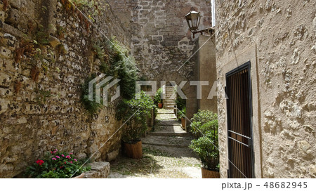 Path between stone walls and houses in Italy 48682945